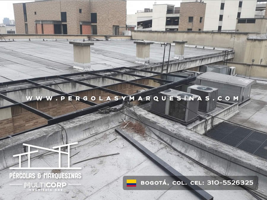 Estructura metálica en construcción para cubierta transparente sobre terraza de edificio comercial en Bogotá, Colombia. Multicorp Ingeniería SAS.
