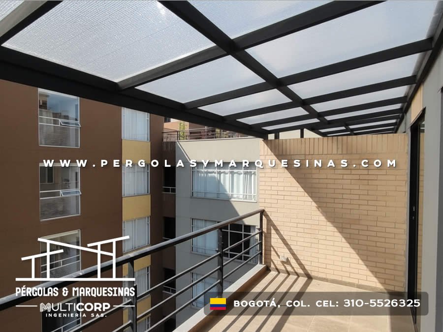Pérgola de policarbonato translúcido con estructura metálica negra sobre balcón de apartamento moderno en Bogotá, Colombia. Multicorp Ingeniería SAS.