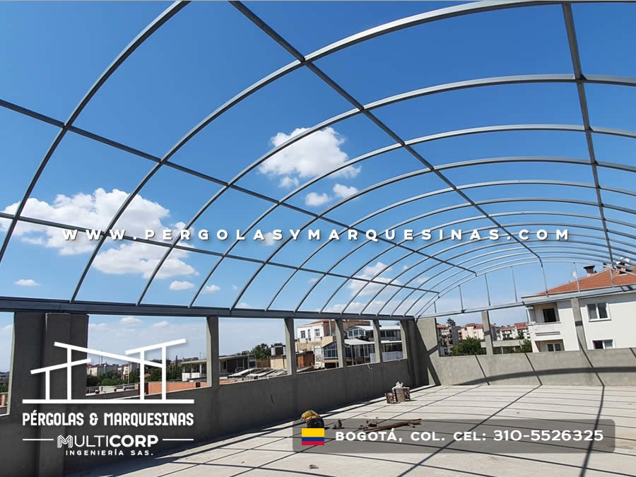 Estructura metálica curva en construcción para domo de policarbonato sobre terraza de conjunto residencial en Bogotá, Colombia. Multicorp Ingeniería SAS.