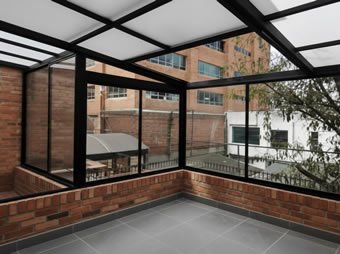 Pérgola metálica en aluminio blanco con policarbonato para terraza y balcón de edificio en Bogotá, Colombia. Multicorp Ingeniería SAS.